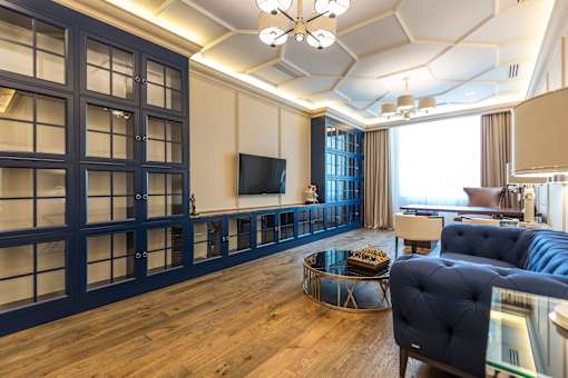 A living room with a dark blue sofa and a glass coffee table.