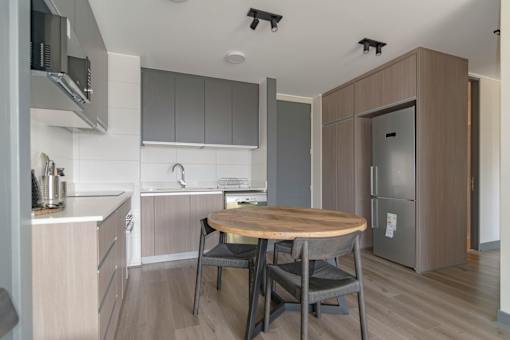 A kitchen with a table and chairs.