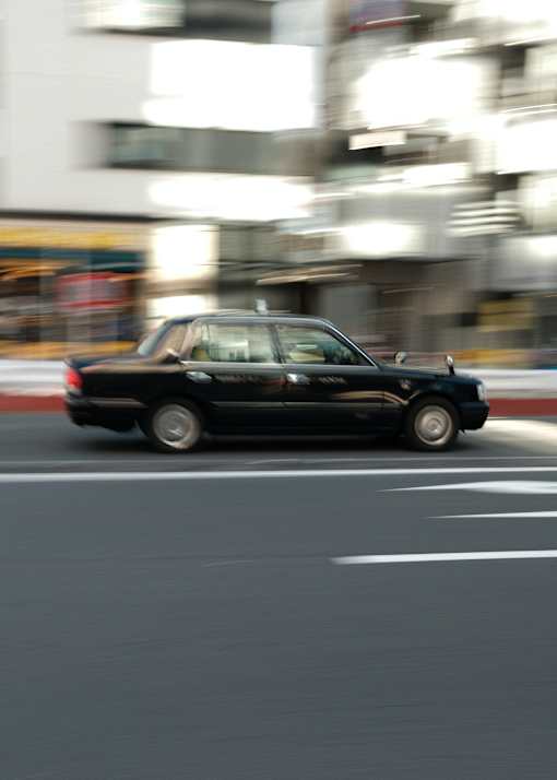a black car driving down a street