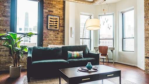 A living room with a black couch and a coffee table.
