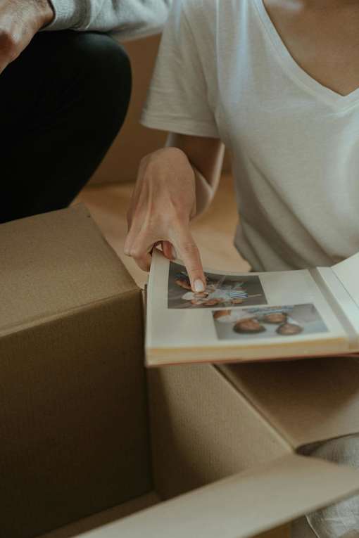 A person is unpacking a box and looking at a photo inside.