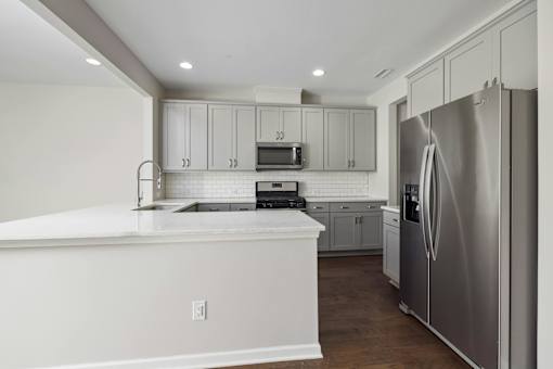 A modern kitchen with stainless steel appliances and white cabinets.