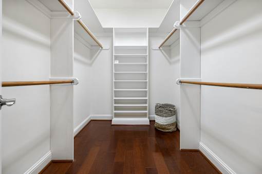 A white hallway with a staircase and a door.