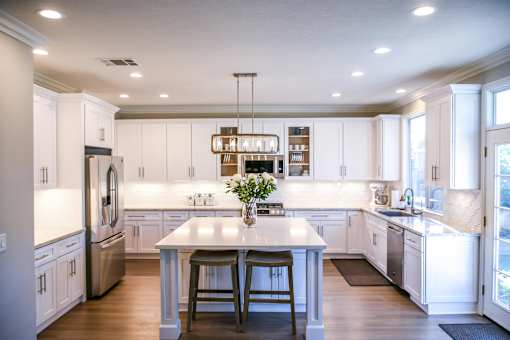A kitchen with white cabinets and a large island.