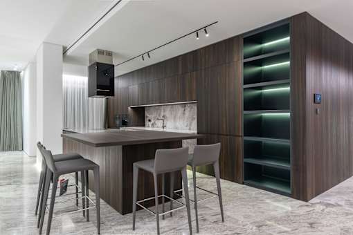a kitchen with wooden cabinets and a bar with three stools