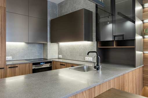 A modern kitchen with a stainless steel sink and wooden cabinets.