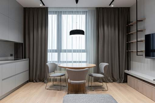 A modern dining room with a round table and chairs.