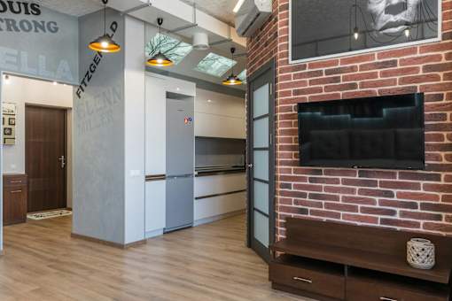 A modern living room with a brick fireplace and a flat screen TV.