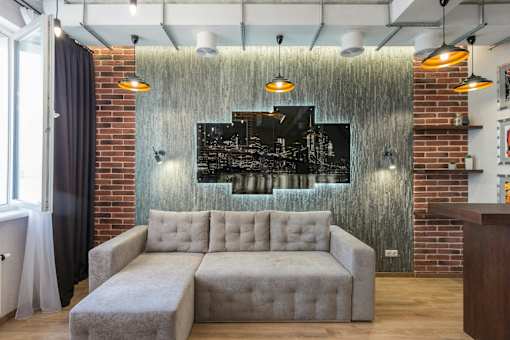 A modern living room with a grey sofa and a cityscape picture on the wall.