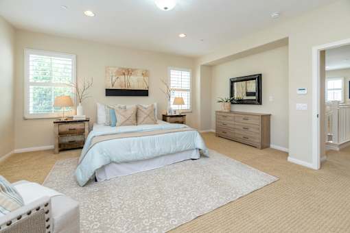 A bedroom with a large bed, a dresser, and a painting on the wall.