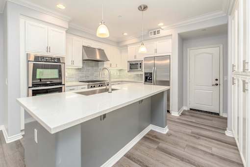 A modern kitchen with a large island and stainless steel appliances.