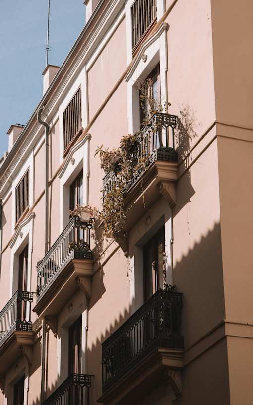 A building with balconies and plants on them.