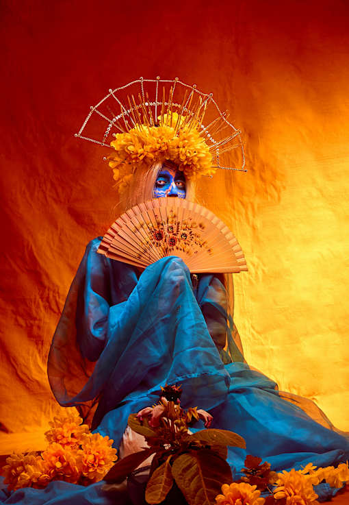 a painting of a woman in a blue dress with a fan and flowers