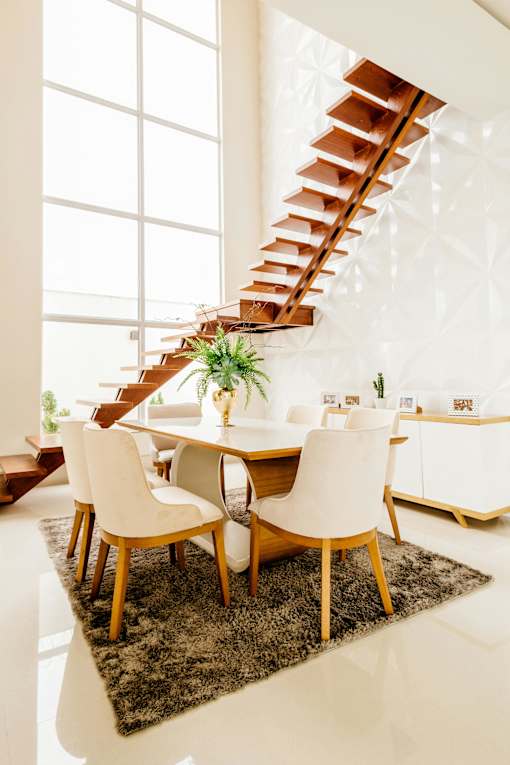 A white dining room with a wooden table and chairs.