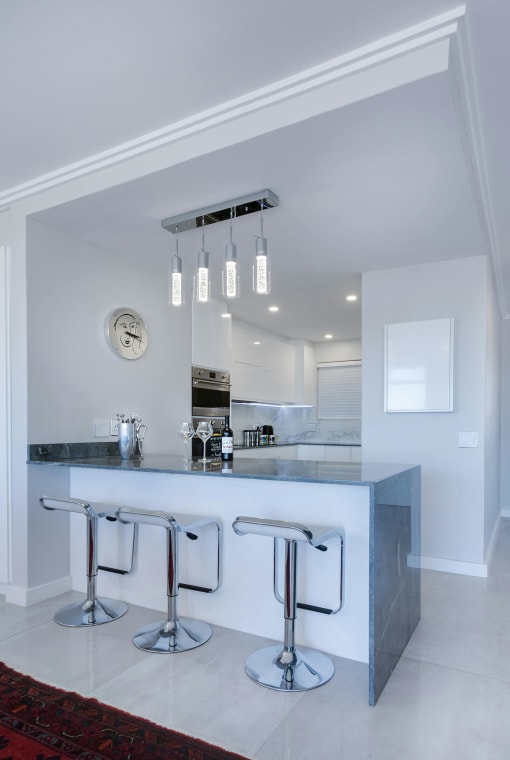 a kitchen with a bar with three stools