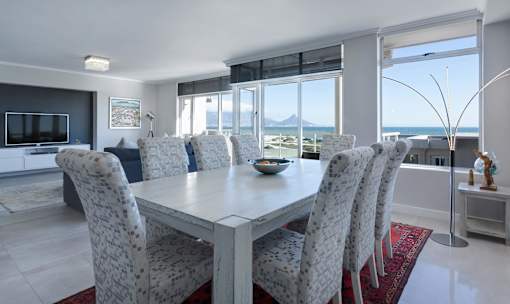 a dining room with a table and chairs and a view of the ocean