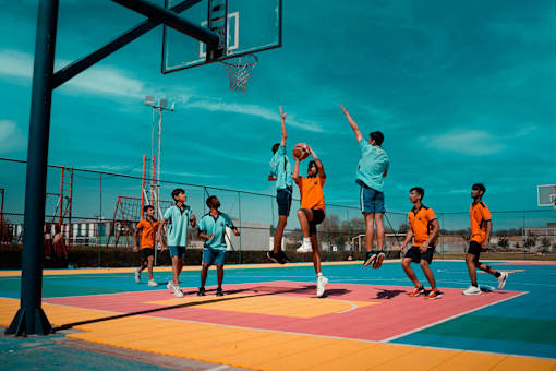 A group of people playing basketball on a colorful court.