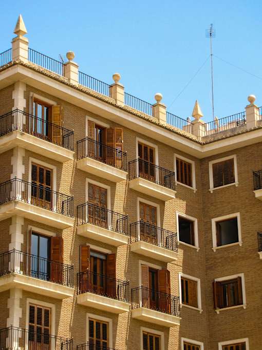A building with balconies and windows under a clear sky.