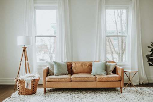 brown leather couch with white wall background