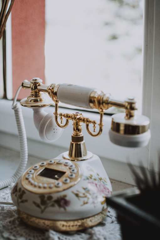 a close up of an old fashioned telephone on a window sill