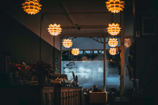 a restaurant with lights hanging from the ceiling