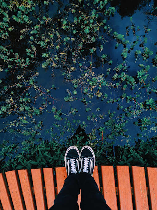a person sitting on a bench with their feet up on