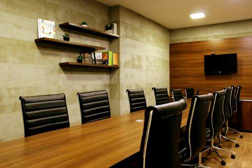 A conference room with a long table and chairs.