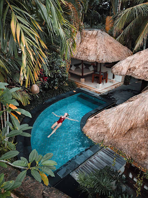 a woman floating in a pool at a resort