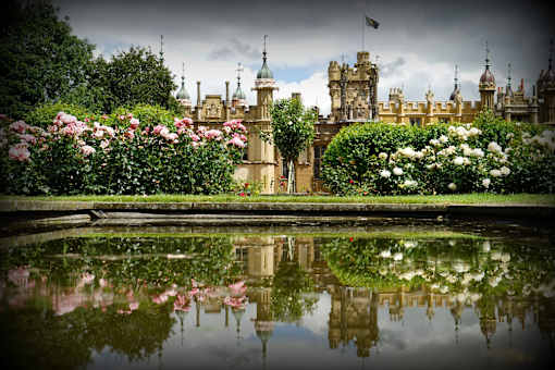 a large castle with a pond in front of it