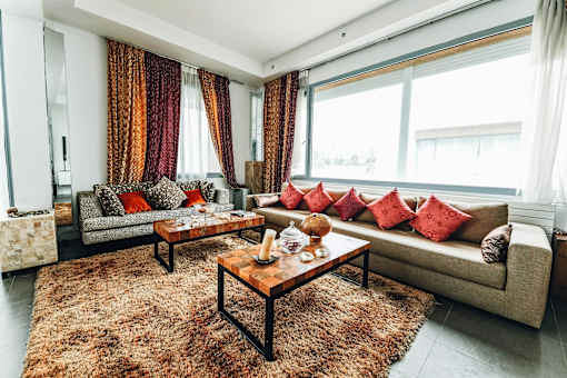 A living room with a couch, coffee table, and curtains.