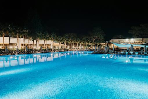 A large swimming pool lit up at night.