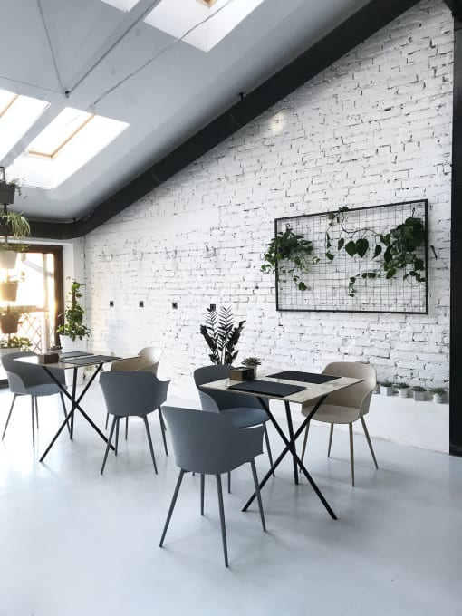 a white room with tables and chairs and a white brick wall
