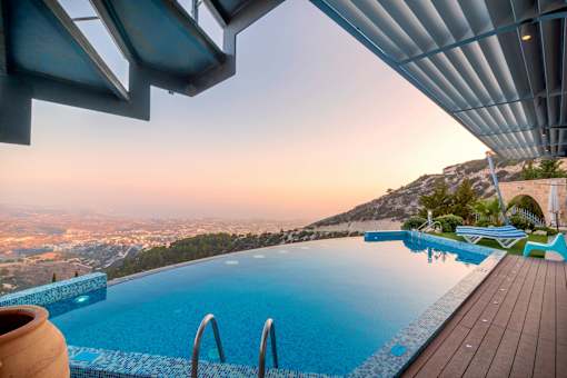 A swimming pool with a view of the cityscape at dusk.