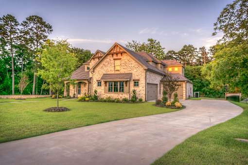 A house with a driveway and trees in the background.