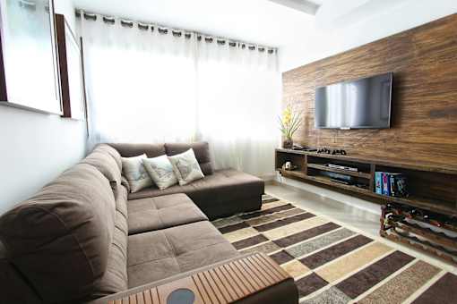 a living room with a large brown couch and a television