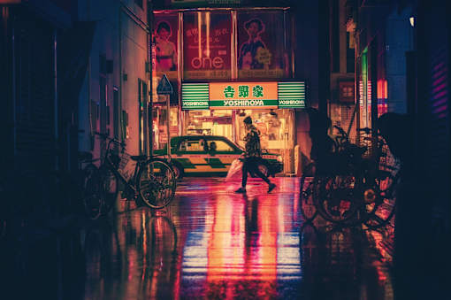 a man walking down a city street at night