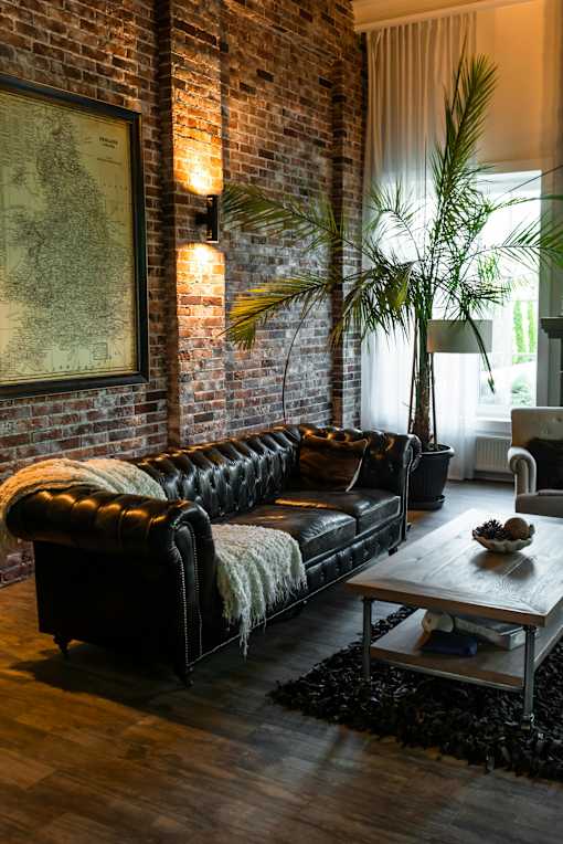 A living room with a black leather couch and a wooden coffee table.