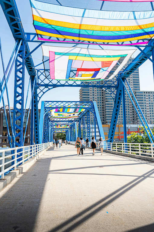 A pedestrian bridge with a blue metal structure and a white walkway.