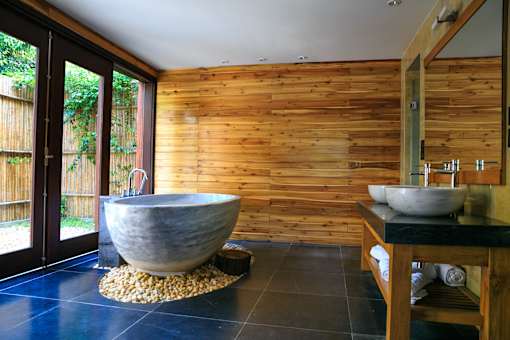 bathroom with blue floor, giant tub, and wooden wall