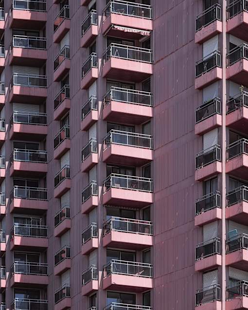 A tall building with balconies on each floor.