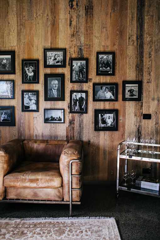 a leather couch sits in front of a wall of black and white photos