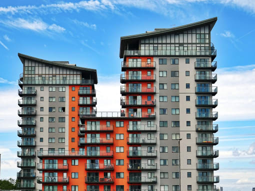 a large apartment building with a blue sky background