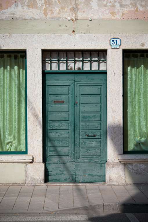 A green door with a number 51 on the wall above it.