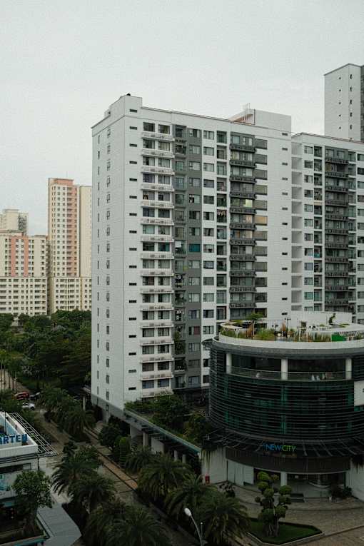 a row of tall apartment buildings with trees in front of them