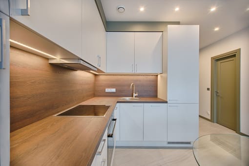 a kitchen with wooden countertops and white cabinets