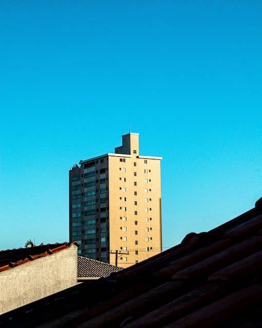 A tall building with a flat roof in the foreground.