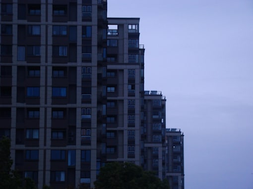 A tall building with many windows is seen in the distance.