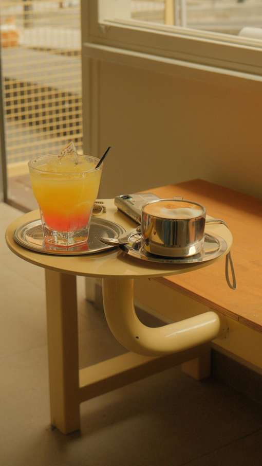 A cup of coffee and a glass of juice on a table.