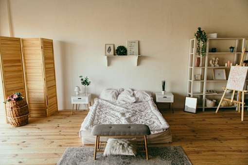 A cozy bedroom with a large bed and a wooden floor.