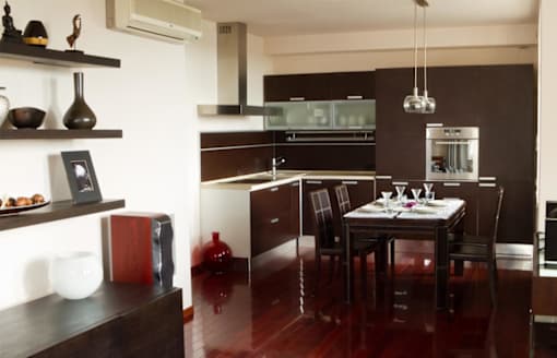 A modern kitchen with dark wood floors and furniture.